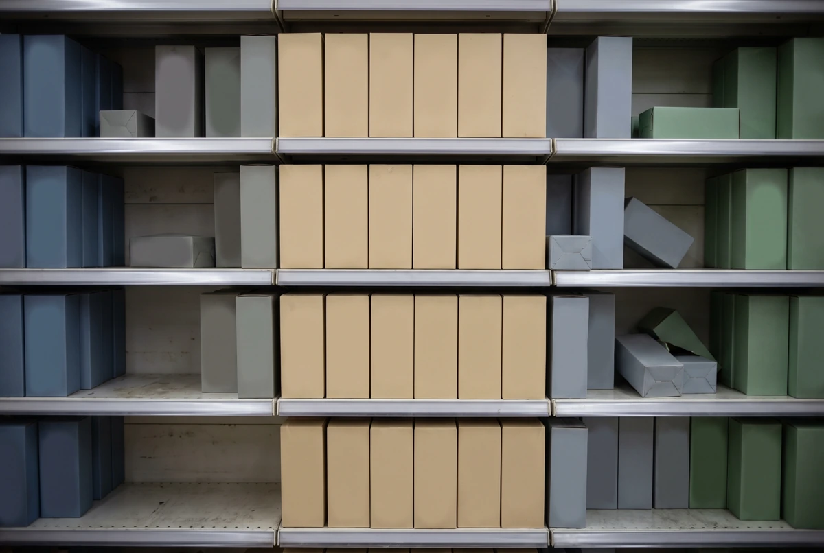 Store shelves with a full central column of boxes and gaps in neighboring stock